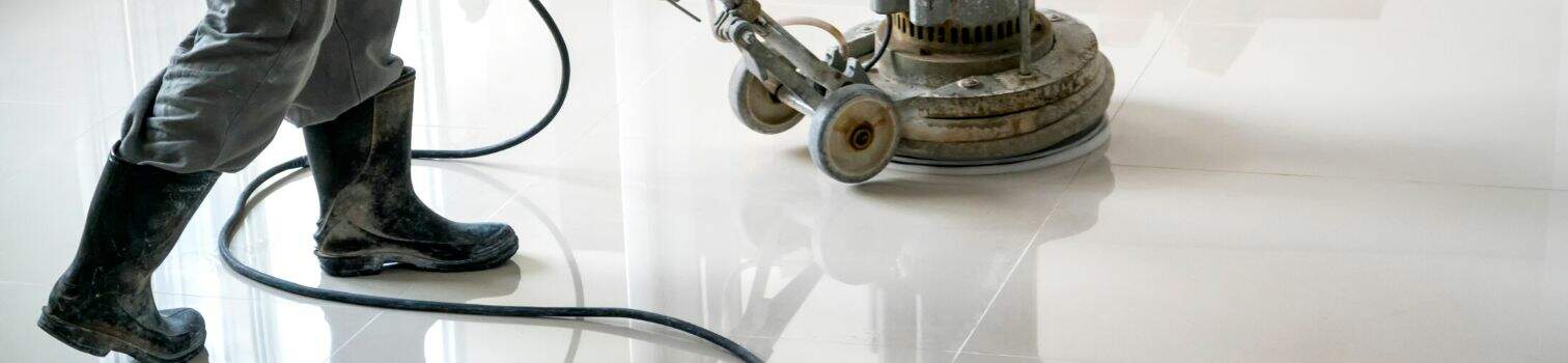 Banner is a cropped image of someone cleaning a tile floor with a buffing machine.