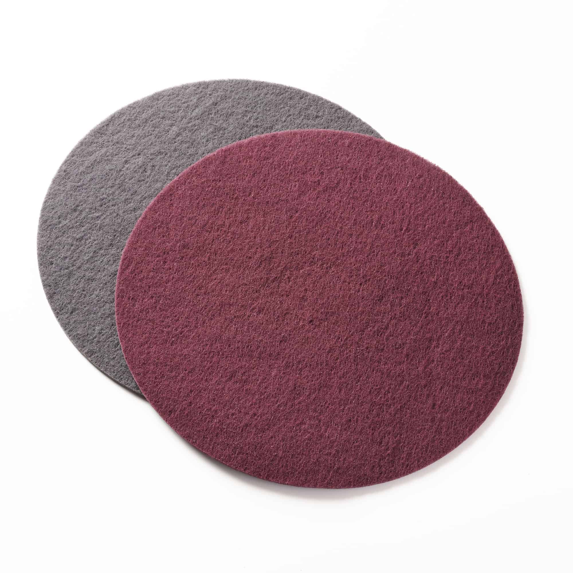 Photo of two scrubbing pads, one grey and one maroon laid over it